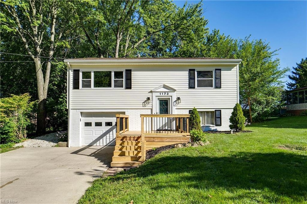 Raised ranch featuring garage, a deck, and a front