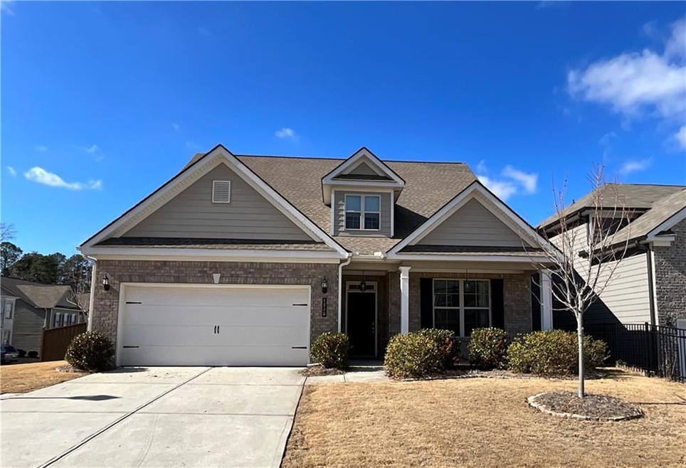 View of front of home with driveway, a garage, fen
