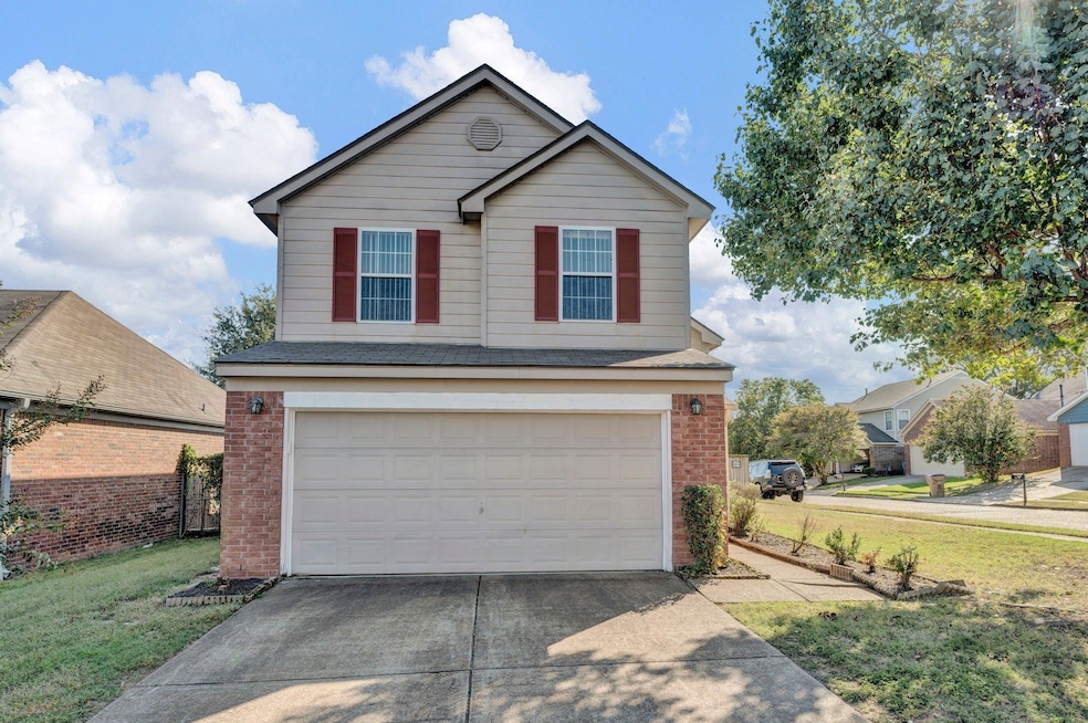 View of property with a garage and a front lawn