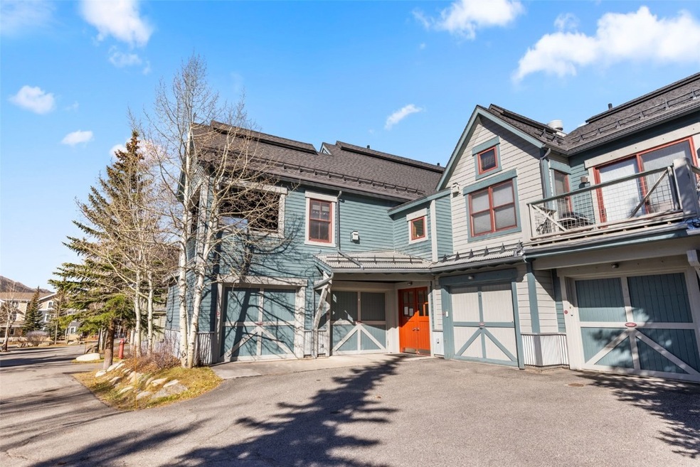 Victorian home featuring a garage, asphalt driveway, and a balcony