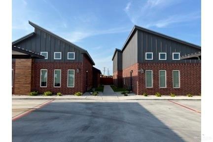 View of side of property with board and batten siding, brick siding, and uncovered parking