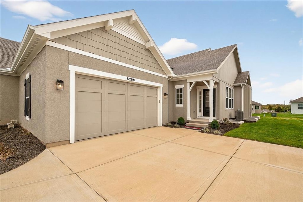 View of front of home with stucco siding, a shingled roof, driveway, and a front yard