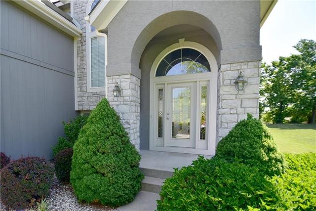 Builder-expanded two-story with dramatic entry