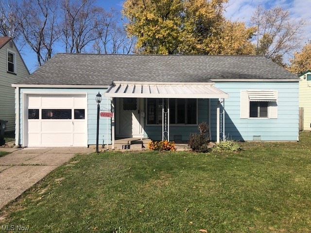 View of front of house with a front lawn and a garage