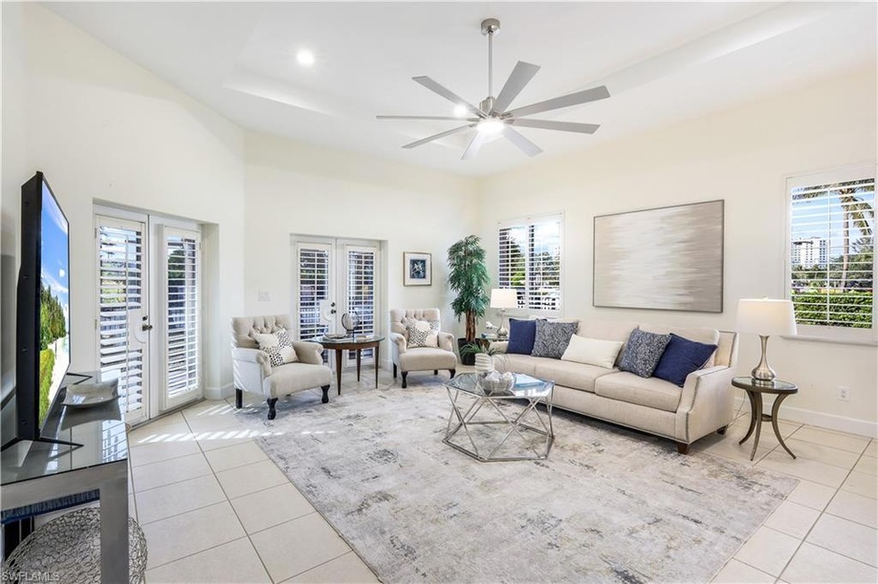 Tiled living room with french doors, a tray ceilin