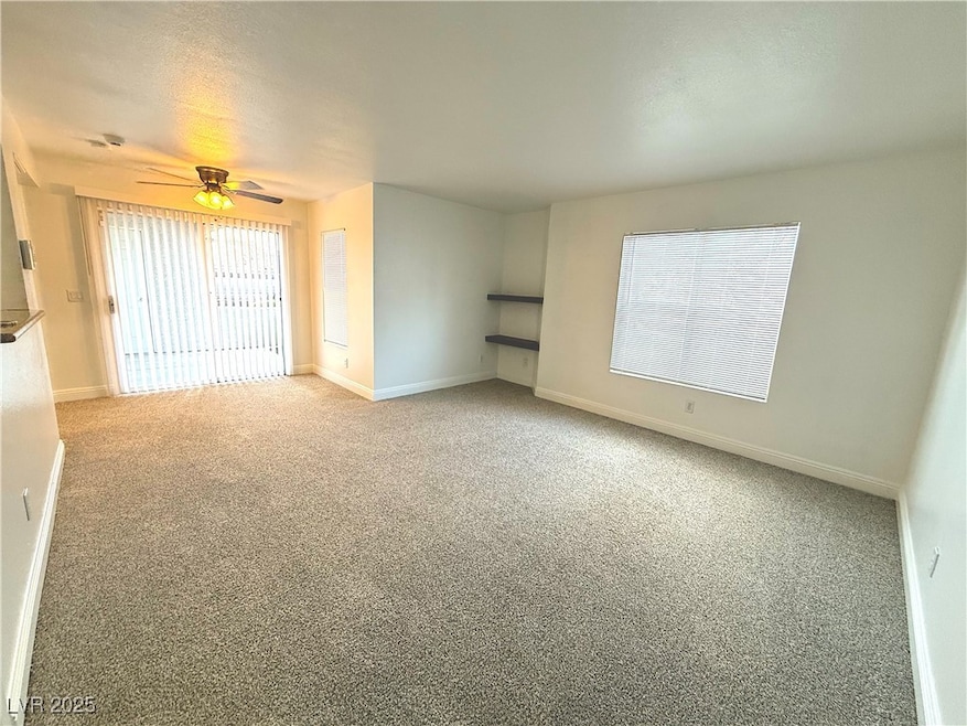 Spare room featuring light carpet and a ceiling fa