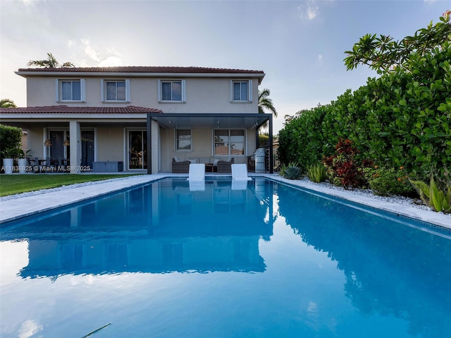 Stunning backyard with plenty of covered areas and a summer kitchen, perfect for entertaining