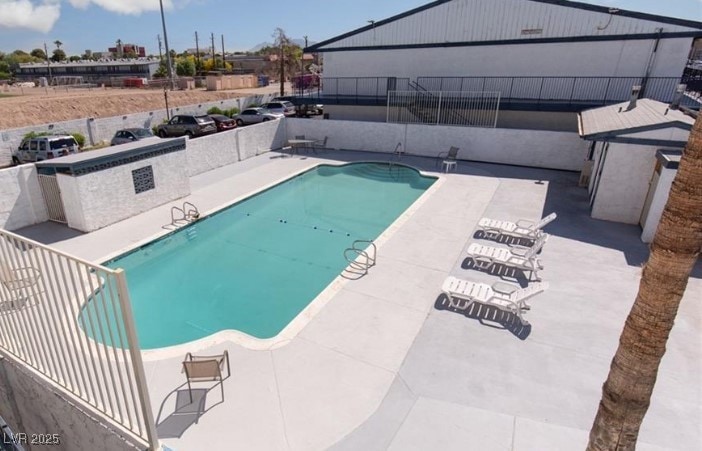 Pool with fence and a patio area