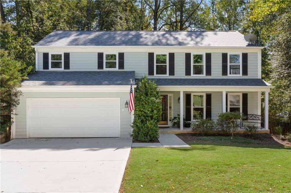 View of front of property featuring a garage, a po