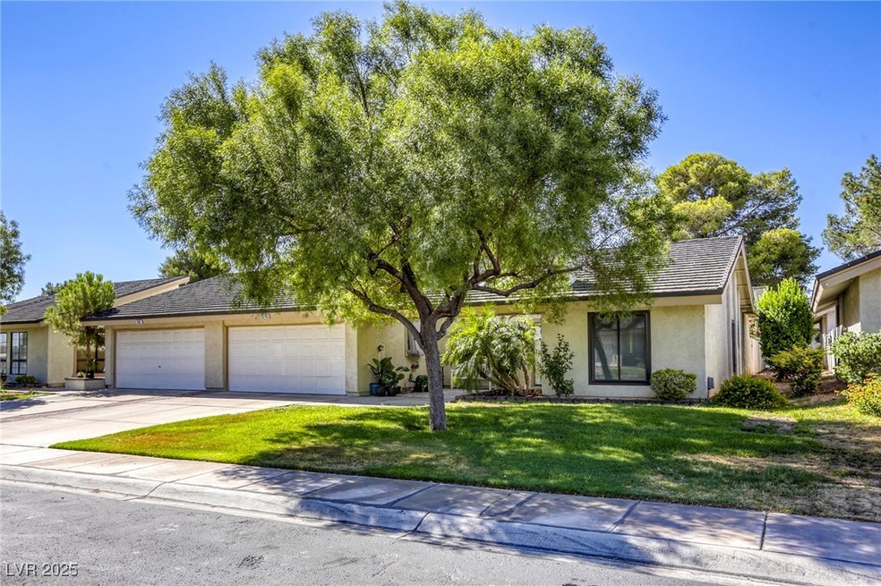 View of front of home with a front yard, an attached garage, stucco siding, and driveway