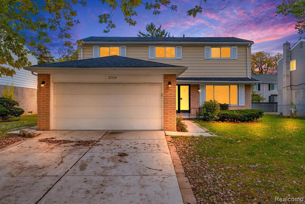 Traditional-style house with brick siding, concrete driveway, and a garage