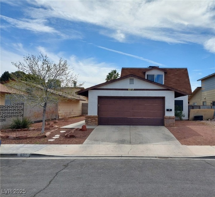 View of front facade with a garage, brick siding,