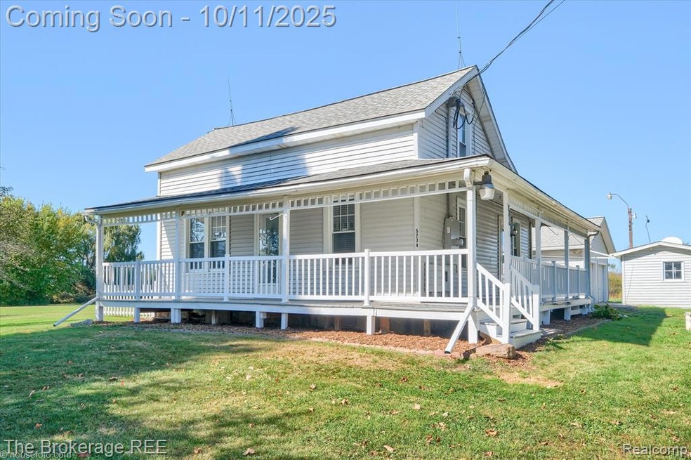 View of front of property featuring covered porch, a front yard, and roof with shingles