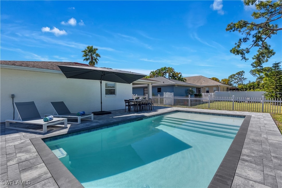 View of pool featuring a patio area, fence, and a