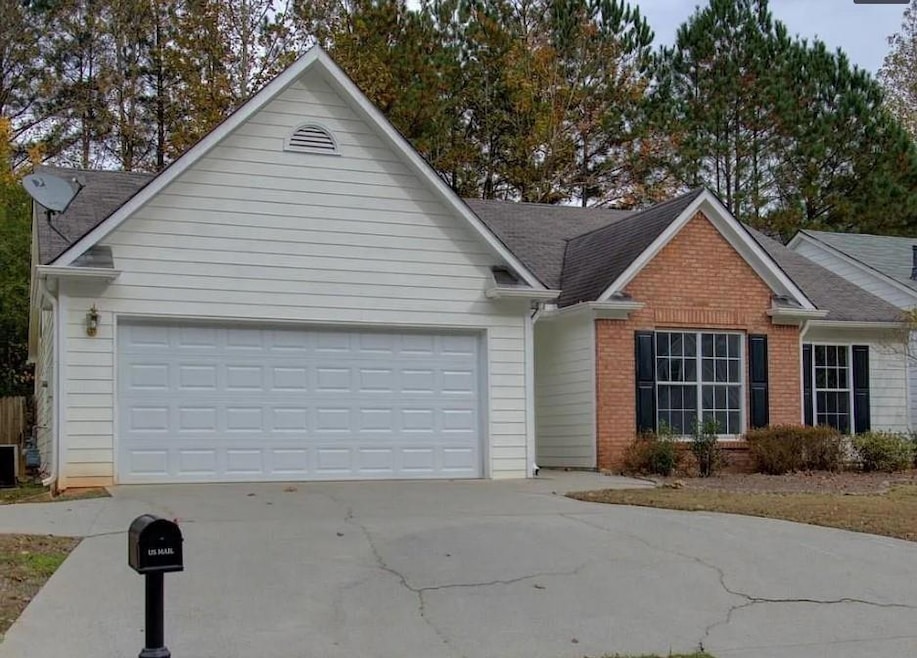 View of front of home featuring concrete driveway, an attached garage, brick siding, and roof with shingles