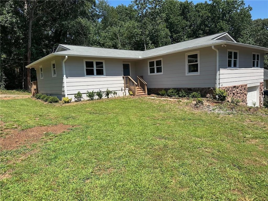 Single story home featuring a front lawn and a garage