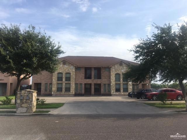 View of front of home featuring stone siding and uncovered parking
