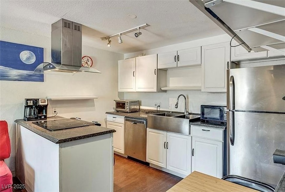 Kitchen featuring dark countertops, wall chimney e