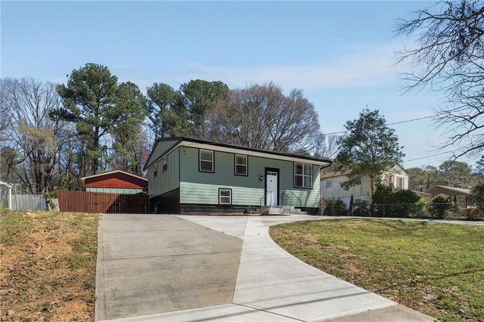View of front facade with driveway, fence, a front