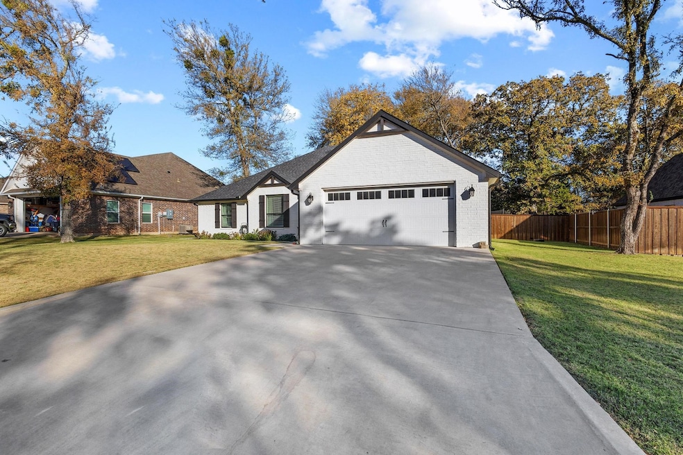 Single story home with brick siding, concrete driveway, and an attached garage