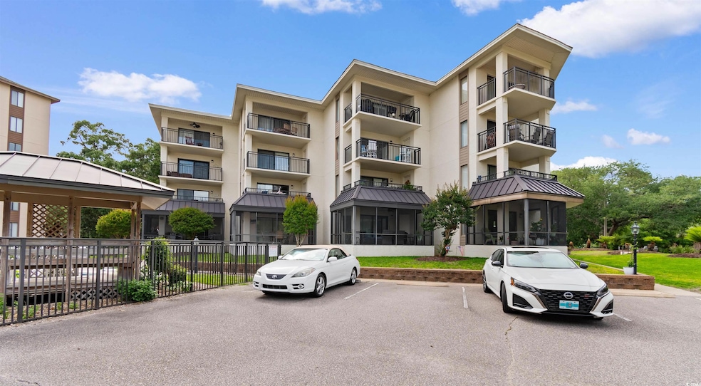 View of apartment building / complex featuring uncovered parking