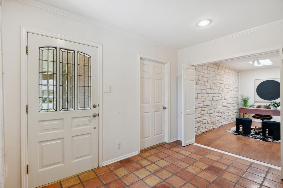 Foyer entrance with baseboards and crown molding