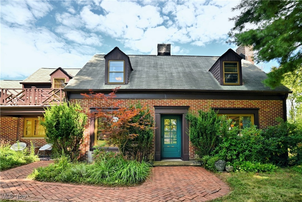 View of front facade featuring a chimney and brick siding