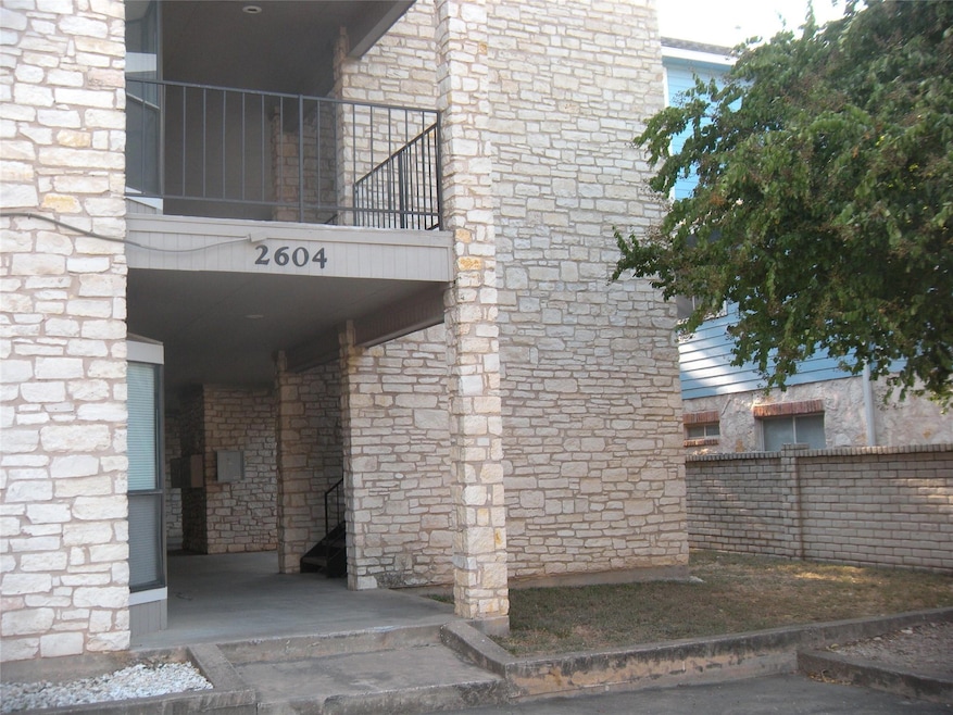 View of exterior entry with stone siding, a balco