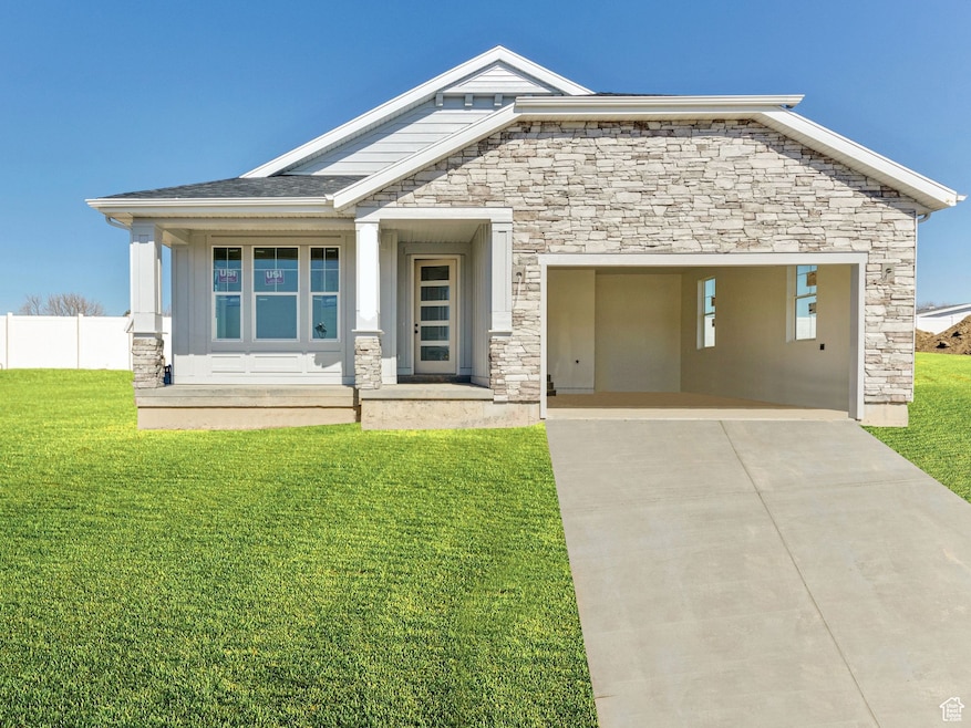 View of front facade featuring concrete driveway, stone siding, a garage, and covered porch