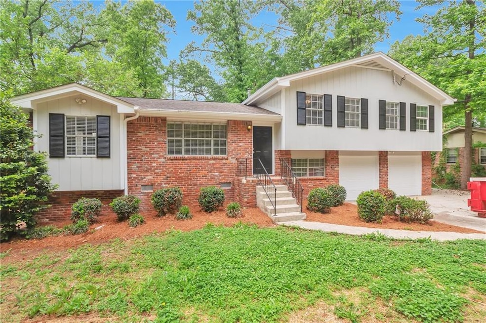 Split level home with concrete driveway, brick sid