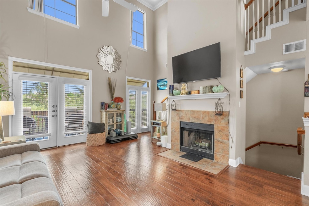 Living room with a towering ceiling, visible vent