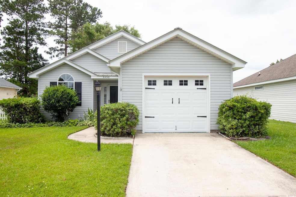 View of front of property with driveway, a front lawn, and an attached garage
