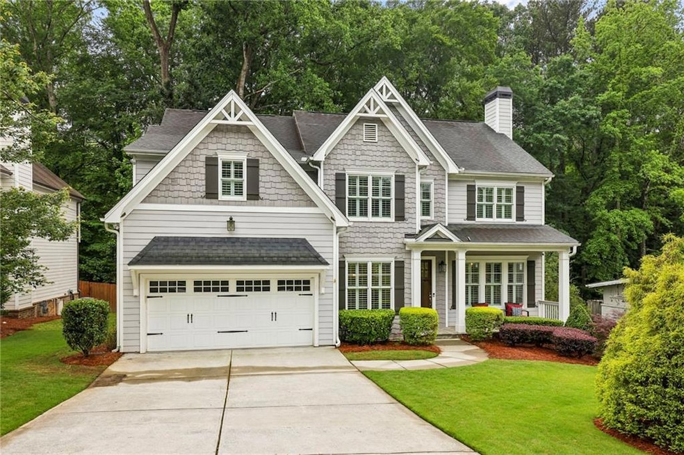 Craftsman house featuring roof with shingles, concrete driveway, and a front lawn