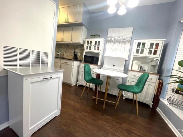 Kitchen with black microwave, a chandelier, taste