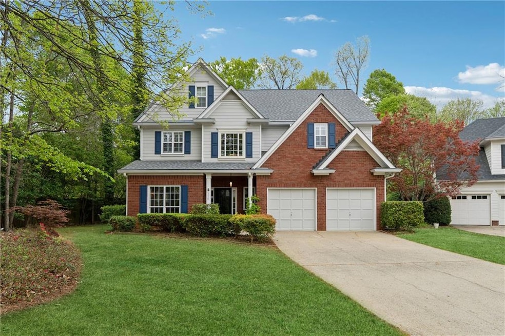 View of front facade with driveway, an attached garage, a front lawn, brick siding, and a shingled roof