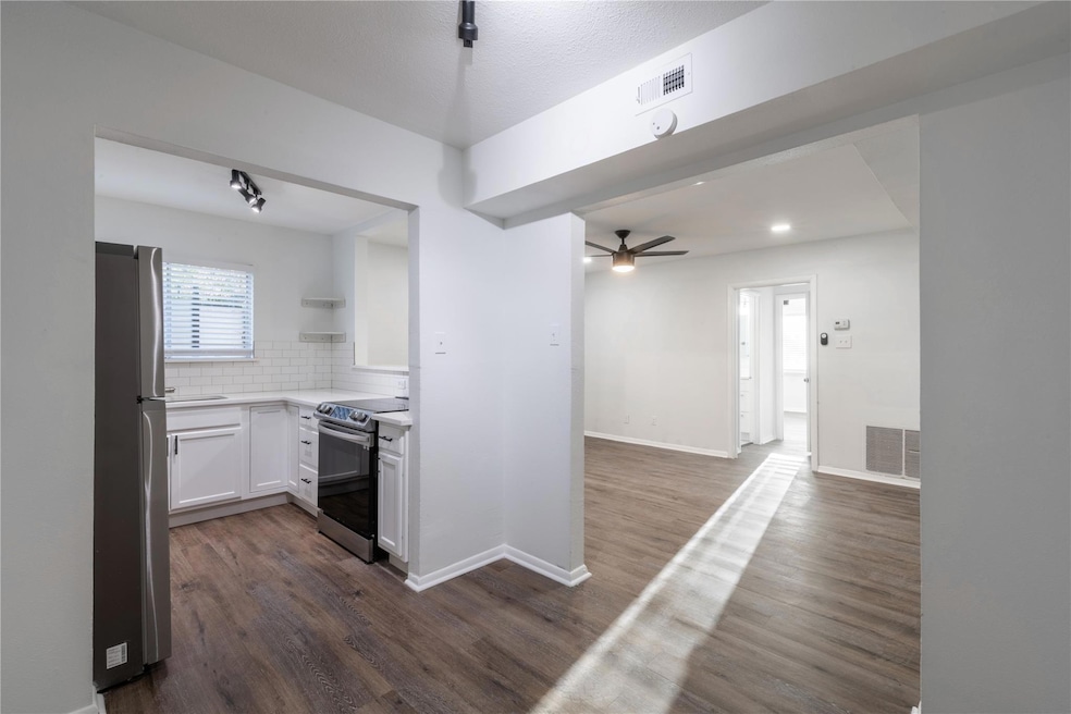 Kitchen featuring white cabinetry, ceiling fan, st