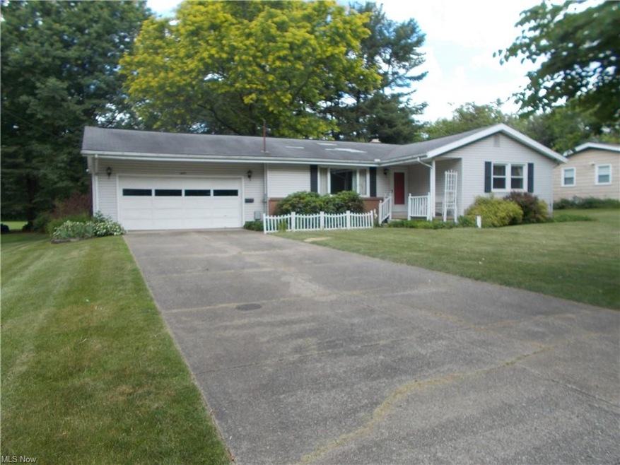 Front view with spacious driveway and manicured la