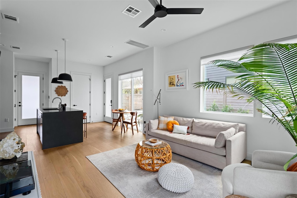Living area with ceiling fan, light wood-style fl