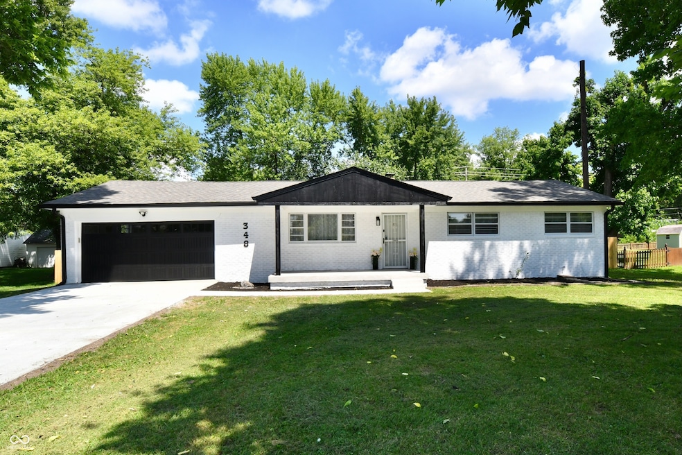 single story home with brick siding, a garage, a front yard, concrete driveway, and a shingled roof