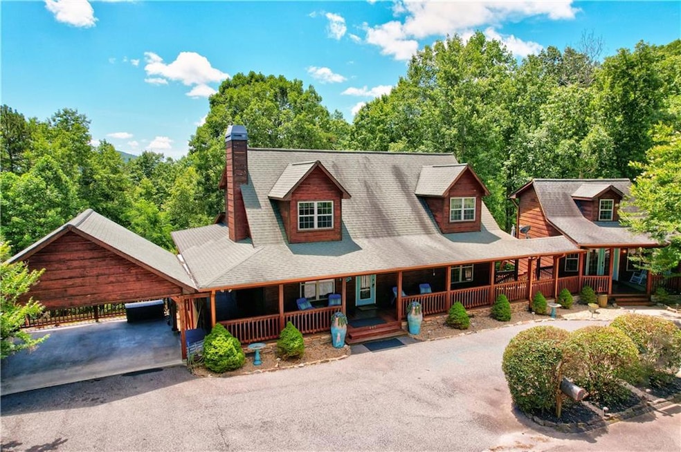 Chalet / cabin with a porch, driveway, a chimney, and roof with shingles