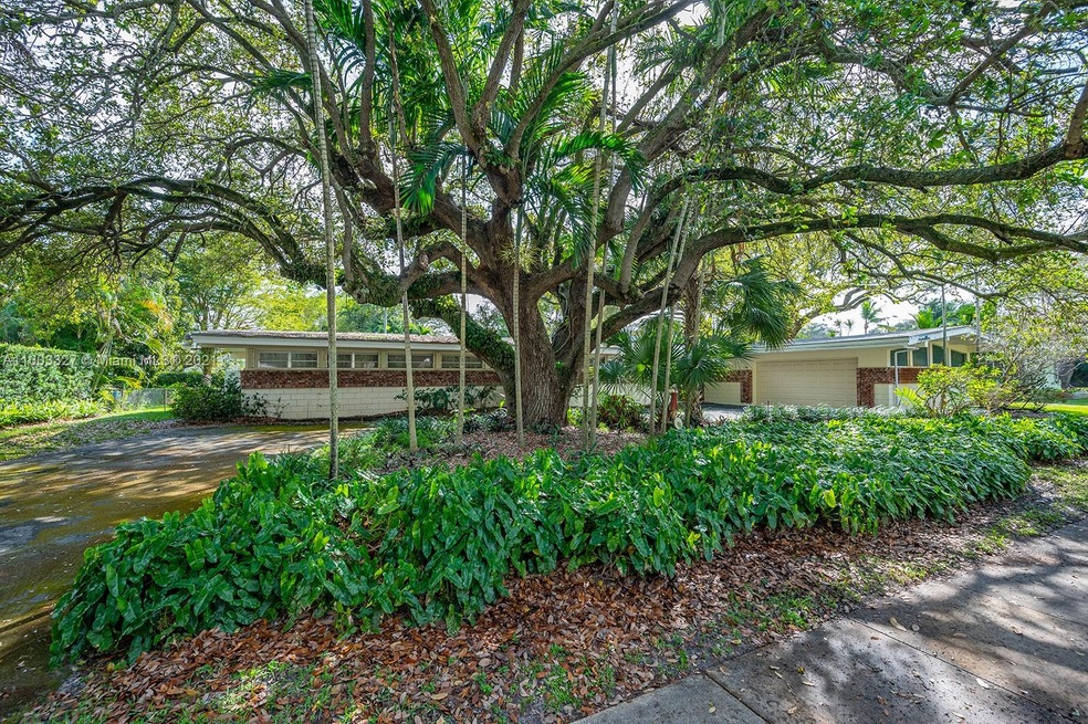 Lush landscaped front of home with circular driveway