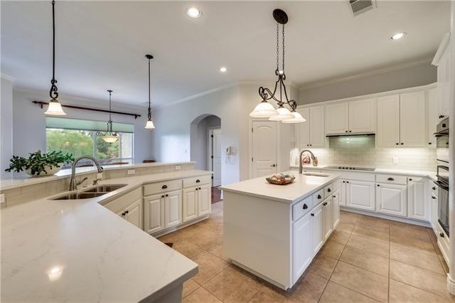 Newly remodeled for you!  Quartz countertops, new glass backsplash, new lighting and freshly painted white cabinets and new hardware make this kitchen pop!  38 Cabinets, all lowers have pull outs!  Fabulous!!