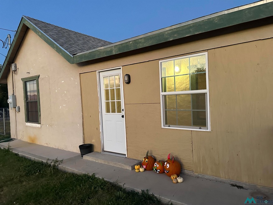 Entrance to property with roof with shingles and stucco siding