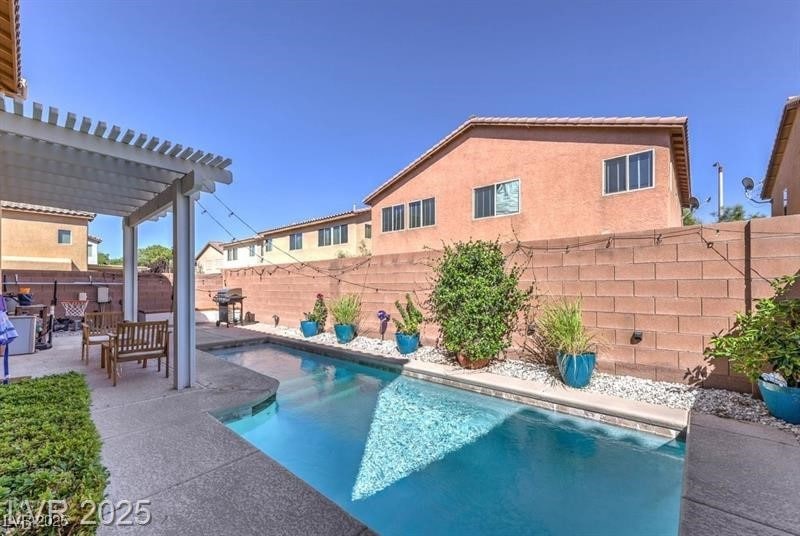 View of swimming pool featuring a pergola, a patio, a fenced backyard, and grilling area