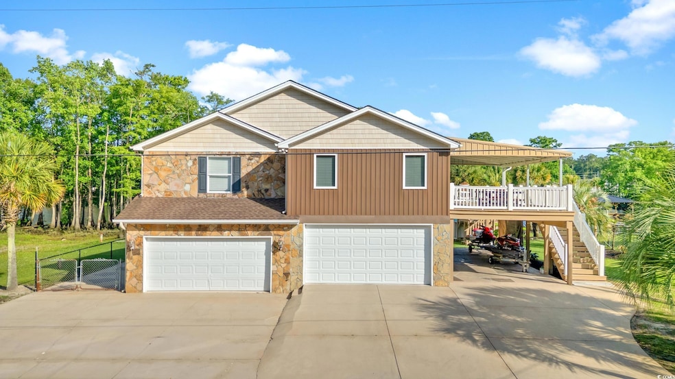 View of front of home featuring stone siding, driveway, a garage, and stairs