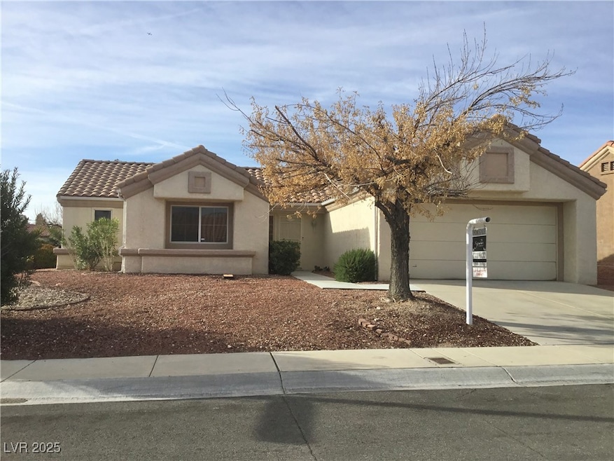 View of front of home with concrete driveway, a ti