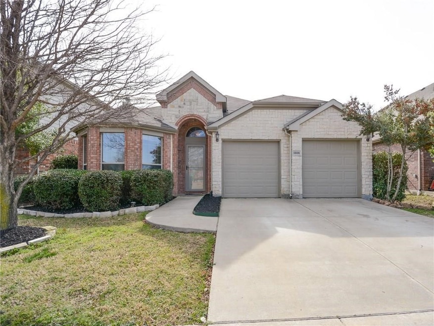 View of front of property with brick siding, concrete driveway, a garage, and a front yard