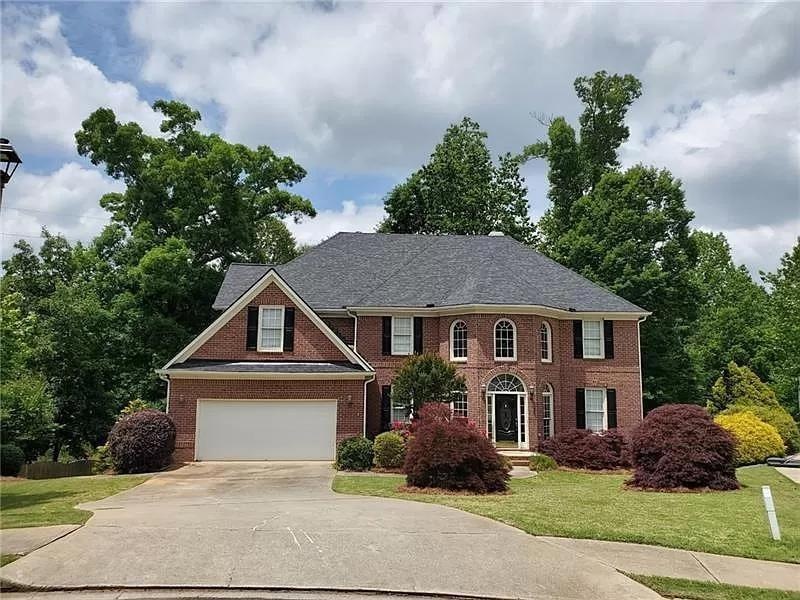 Colonial home with a garage and a front lawn