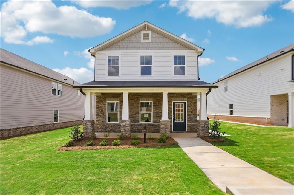 View of front facade featuring stone siding, a por