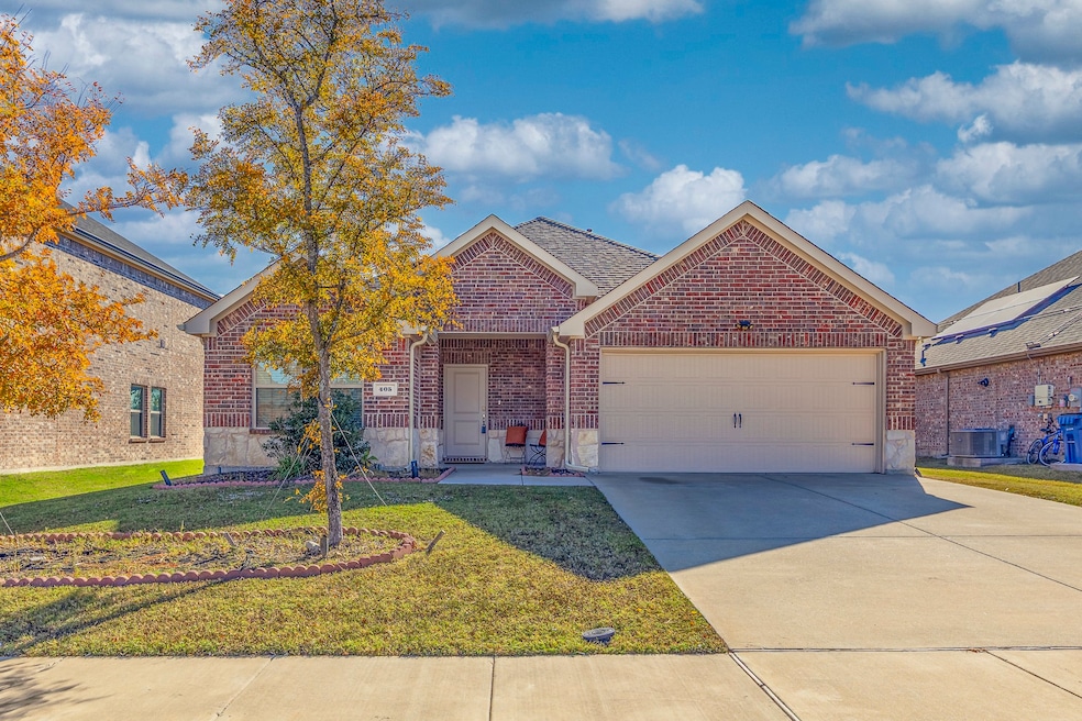 View of front of property featuring brick siding, a front yard, driveway, and an attached garage
